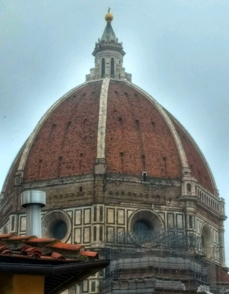 Florence's red-tiled Duomo dome up close, showing missing marble and tiles.