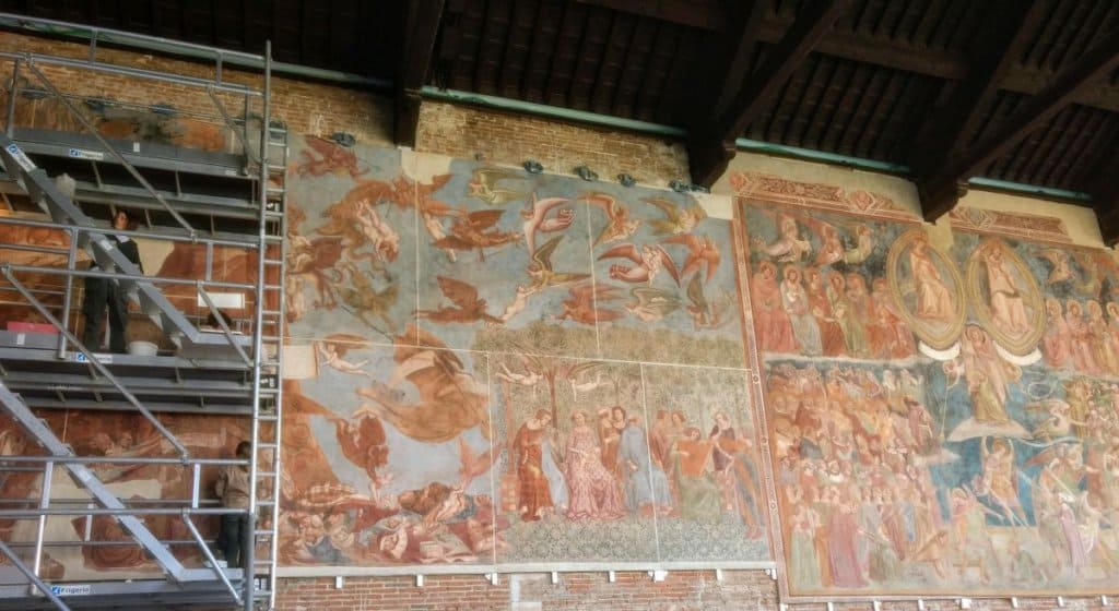 Pisa camposanto frescoes undergoing restoration with scaffolding nearby.
