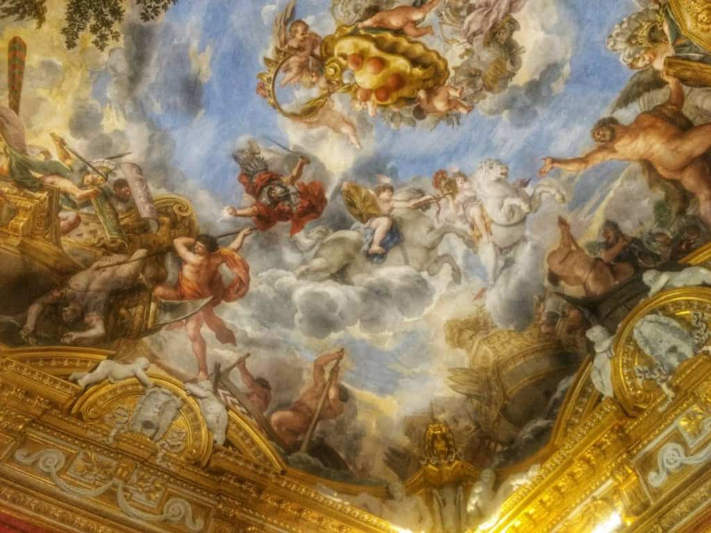 Frescoed ceiling of angels with a blue sky and clouds.