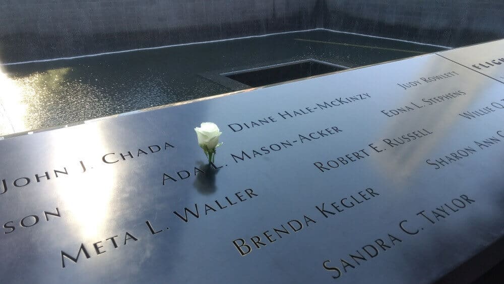 white rose in a name carved into the 9/11 Memorial in Mew York City