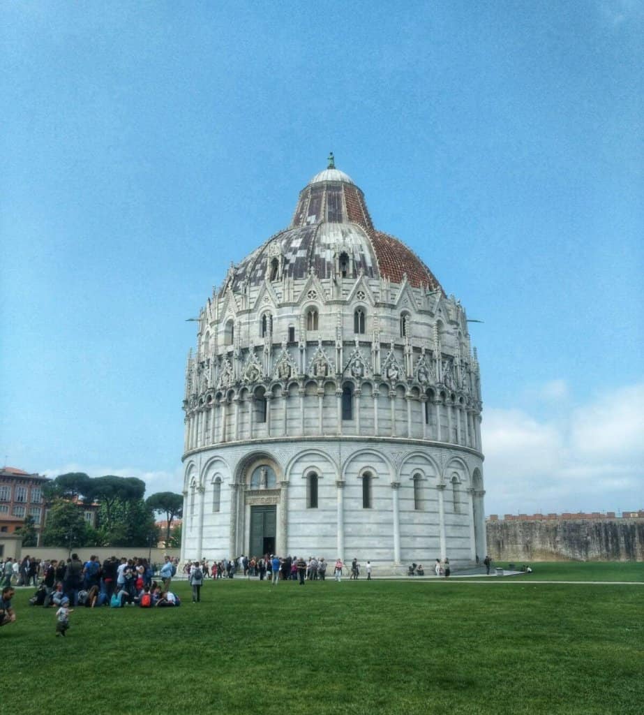 Exterior of a large, marble baptistery in Italy.