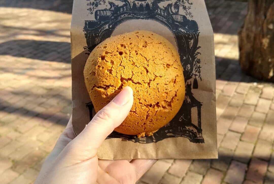 Hand holding a small round cake.