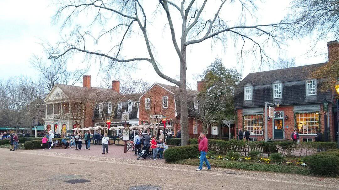 People walking through an 18th century style shopping area.