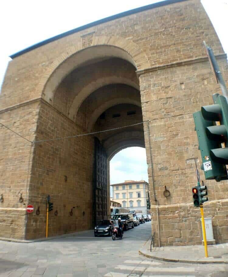 The old Florence wall gate with cars driving through it