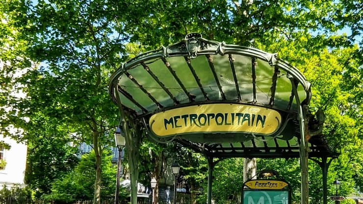 Art Nouveau Paris metro stop with green wrought iron and glass canopy