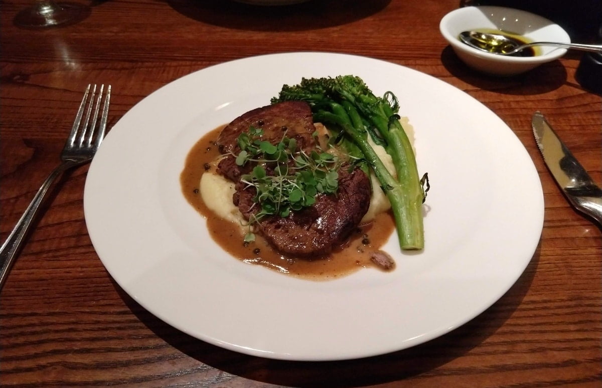 Steak and broccolini on a white plate at The Bistro at Biltmore Estate Winery