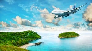 Airplane flying over islands with clear blue water