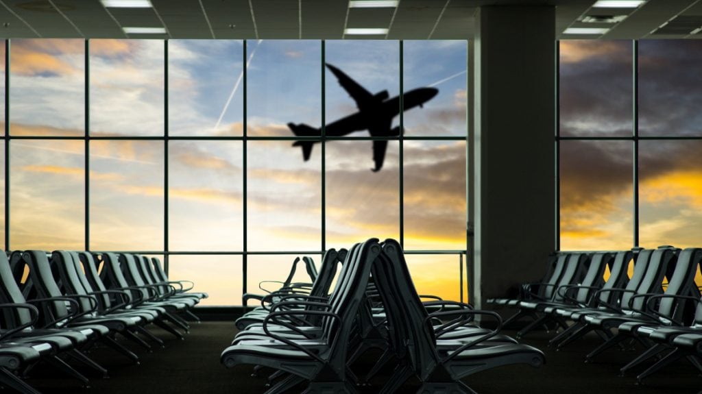 View of an airplane through the window of a airport gate waiting area