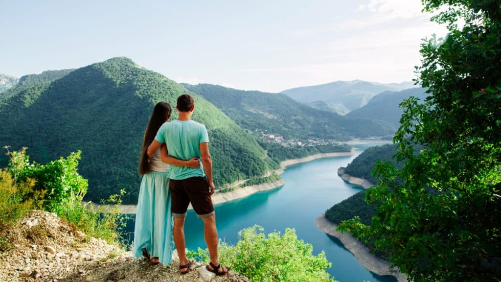 couple relax on peak of mountains with landscape view