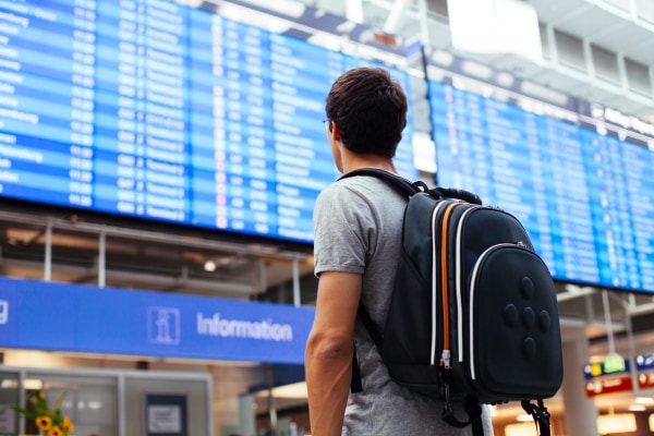 man with a backpack carry-on packed for a long-haul flight