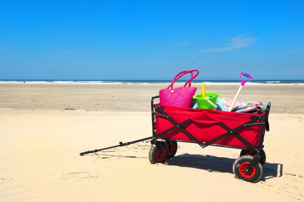 Red beach wagon filled with beach accessories