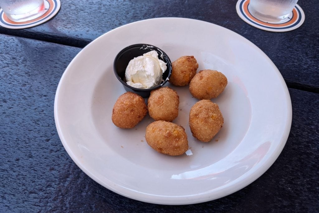 Six hushpuppies in a white bowl on a table