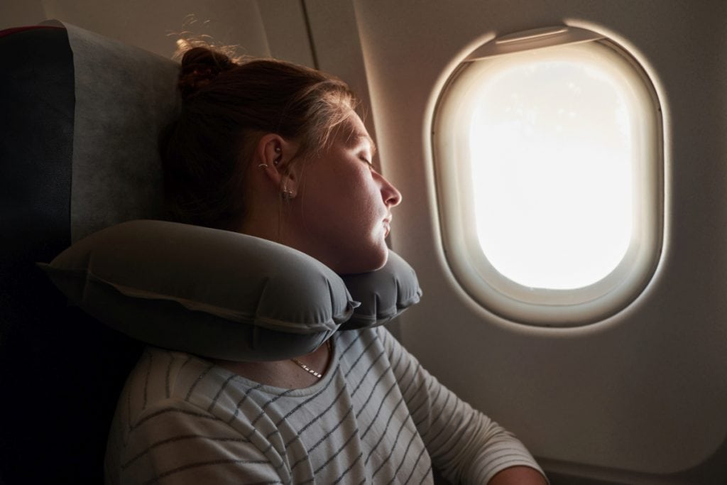 woman sleeping in an airplane window seat