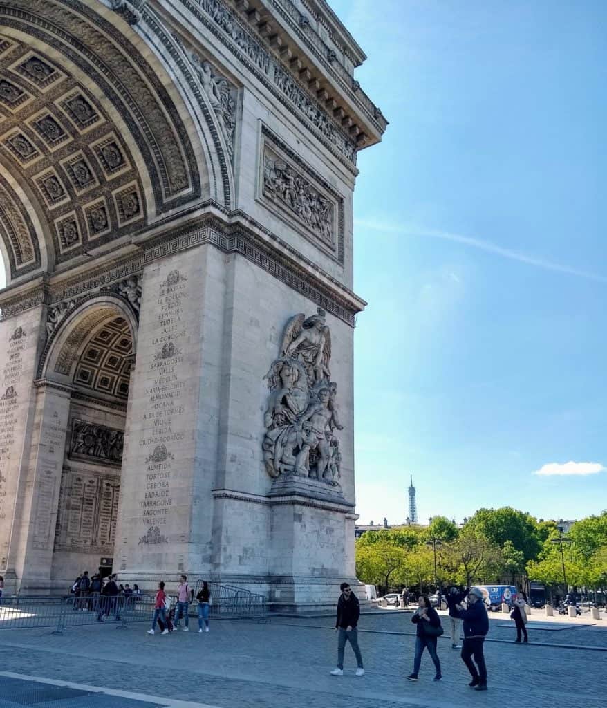 tourists milling about at the base of the Arc de Triomphe