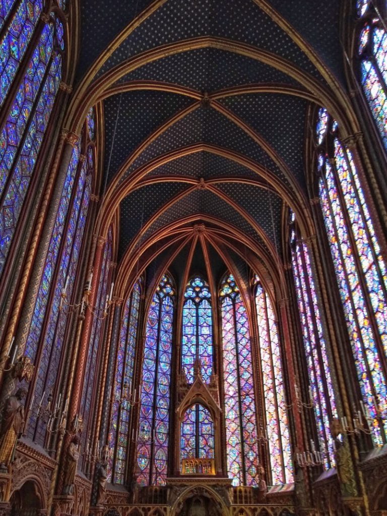 light shining through a wall of tall stained glass windows