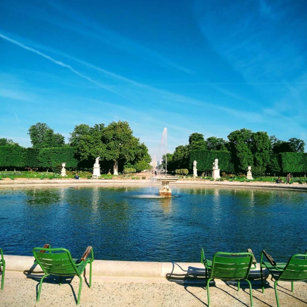 fountain with green chairs around it in the Tuileries park in Paris