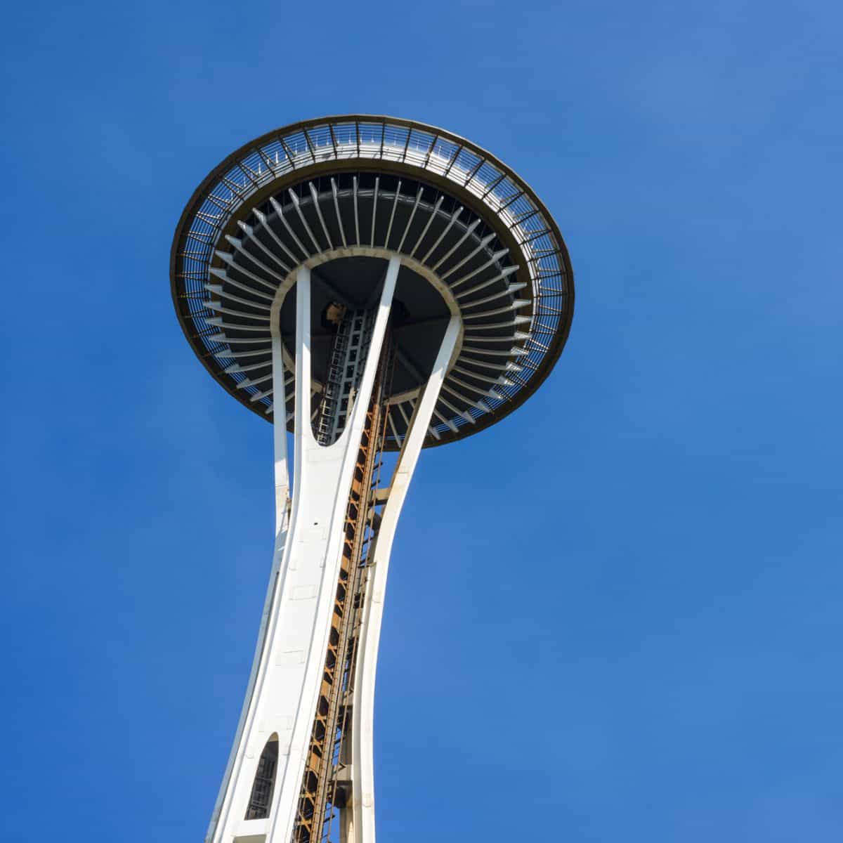 view of the Space Needle in Seattle from below against a clear blue sky