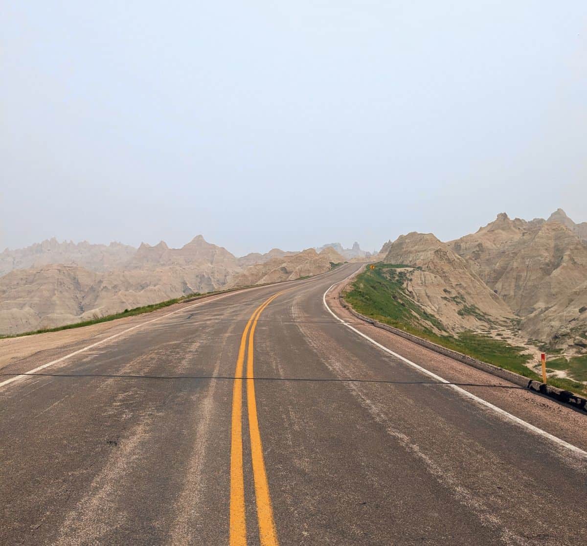 two-lane road with rock formations on either side of the road