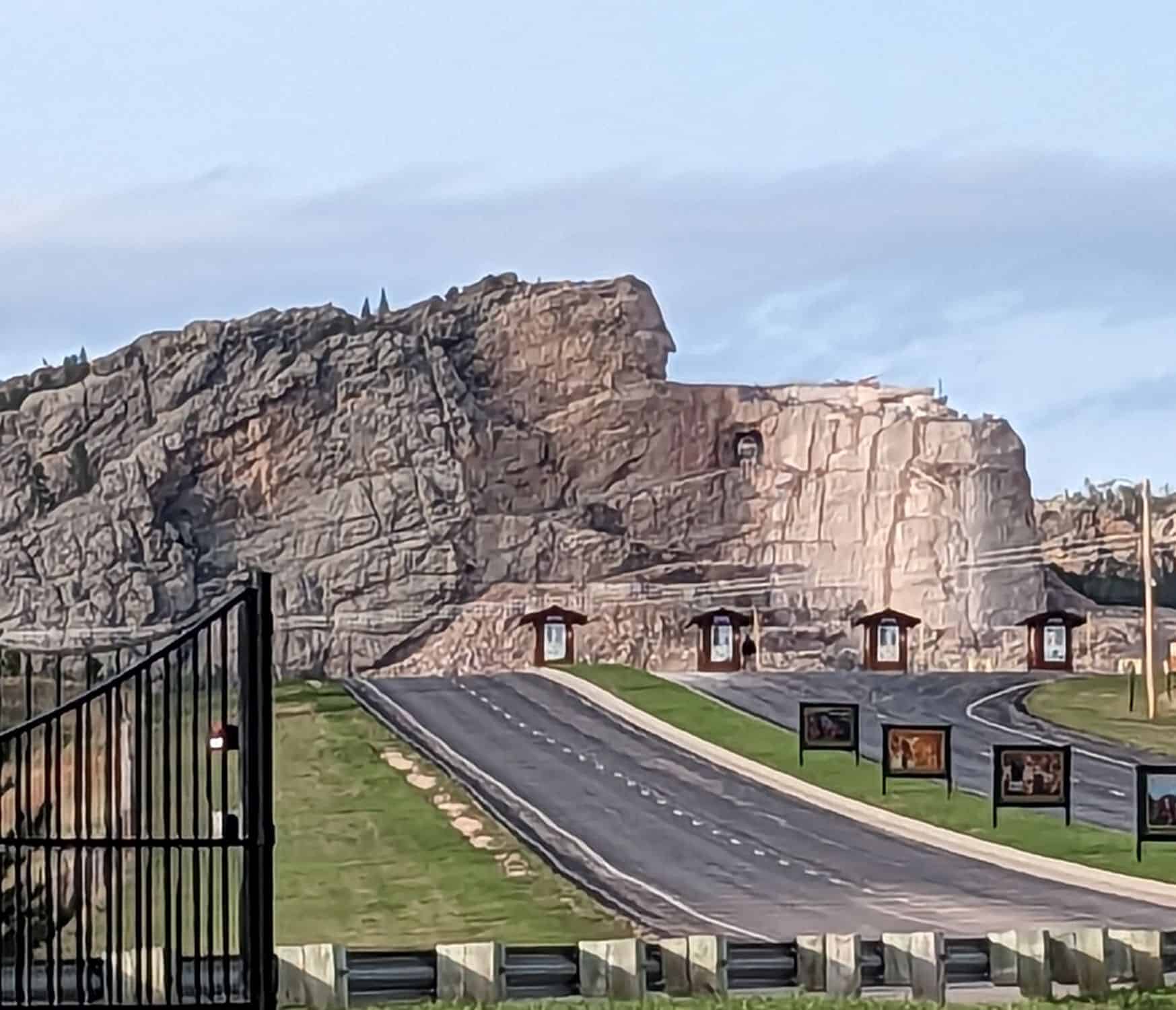 large, partially completed stone sculpture in the side of a mountain