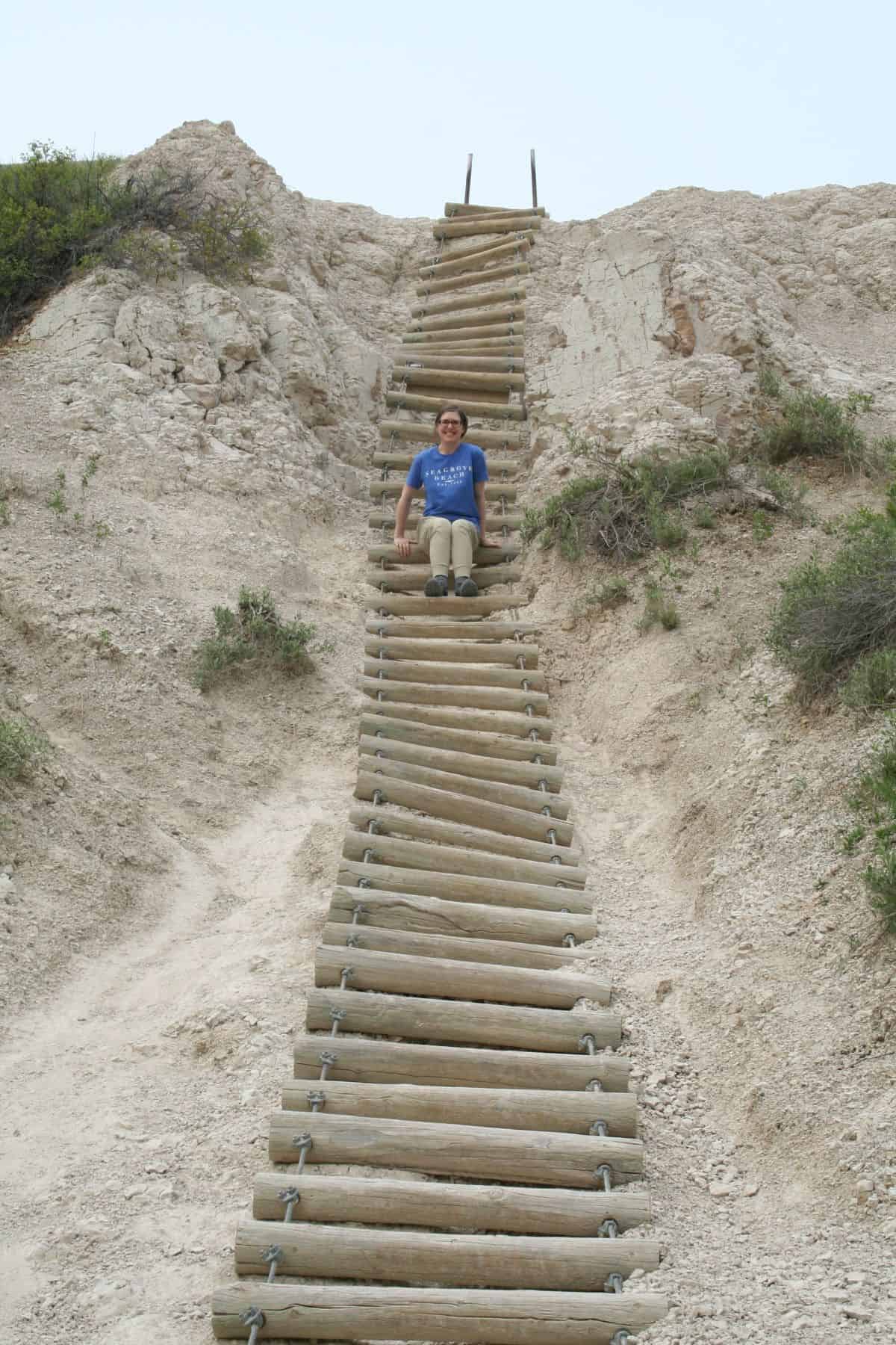 woman climbing down the Badlands National Park Notch Trail ladder