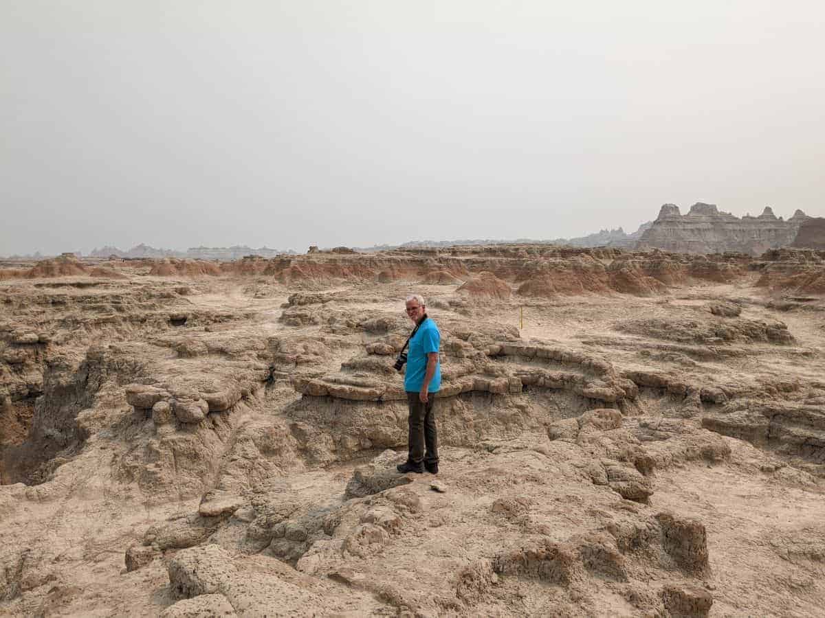 Man standing on rock formations in Badlands National park