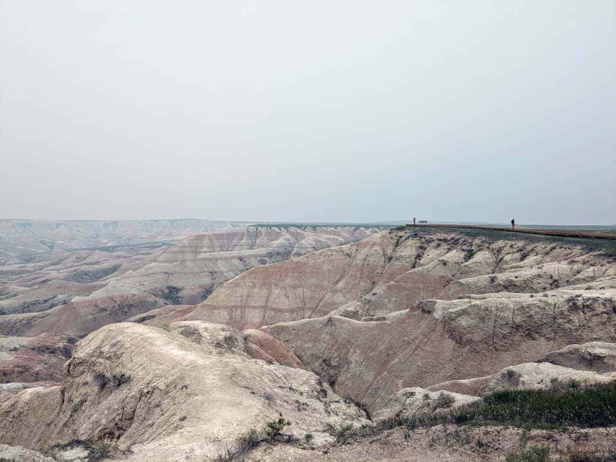 grassy area overlooking striped badlands rock formations