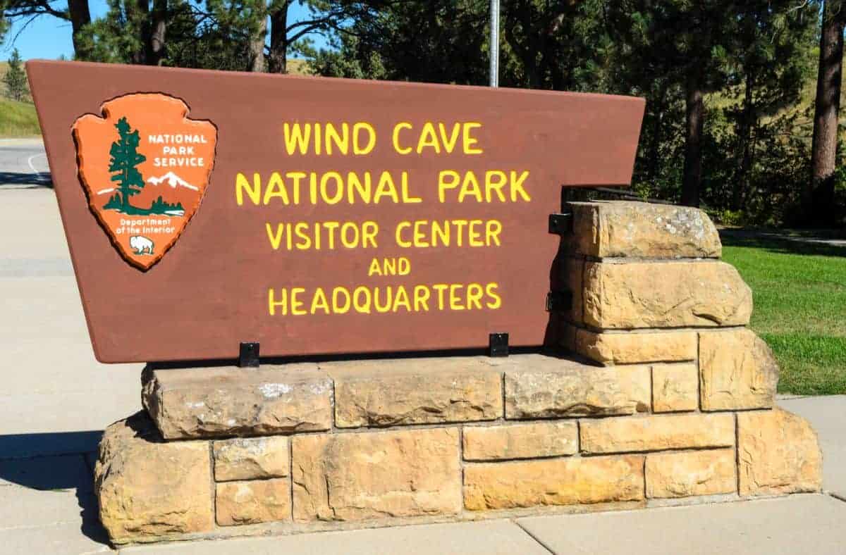 Stone and wood sign that reads Wind Cave National Park Visitor Center and Headquarters