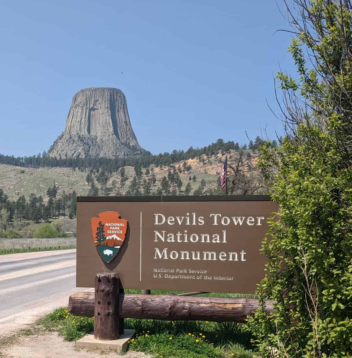 Devils Tower National Monument sign with tower in the distance