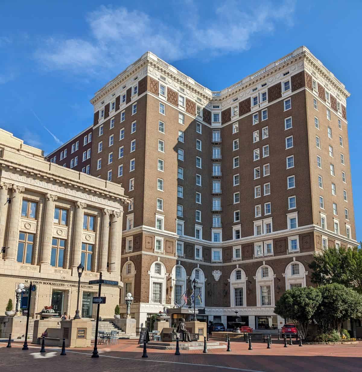 tall brick historic hotel next to a bookstore with white columns out front