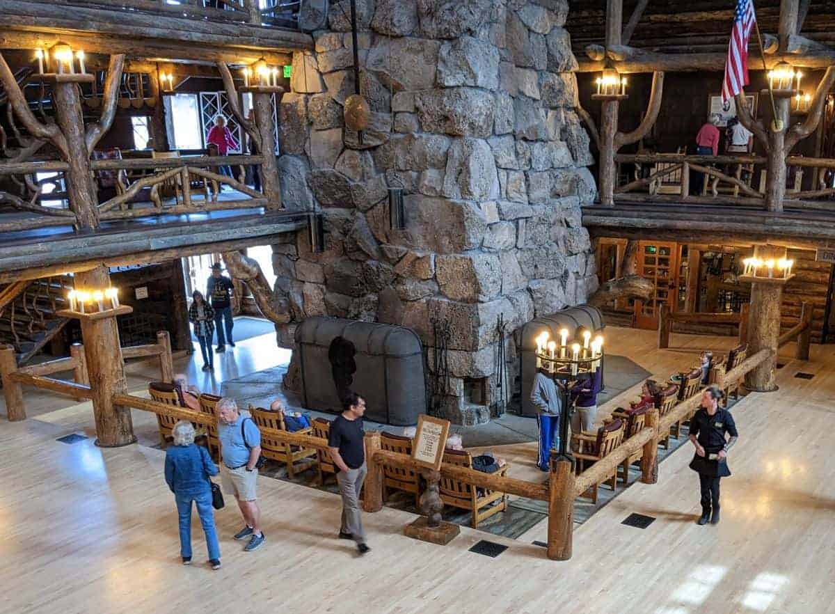 People milling around in a large wood and stone hotel lobby.