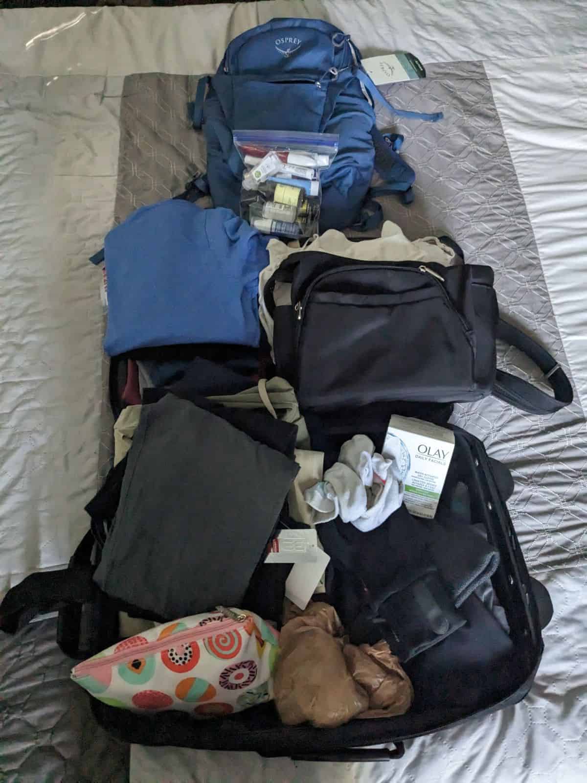 Displayed travel bag with clothing, toiletries, and accessories for a two-week trip.